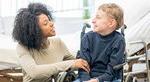 职业治疗师助理与一个坐在轮椅上的孩子一起工作