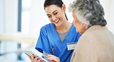 Patient Care Coordinator reviewing patient chart with elderly patient